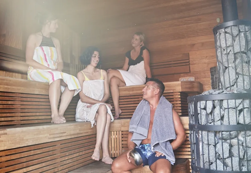 En gruppe mennesker som sitter i en badstue.