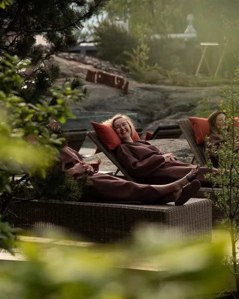 En kvinne som ligger på en sofa ved siden av et tre.