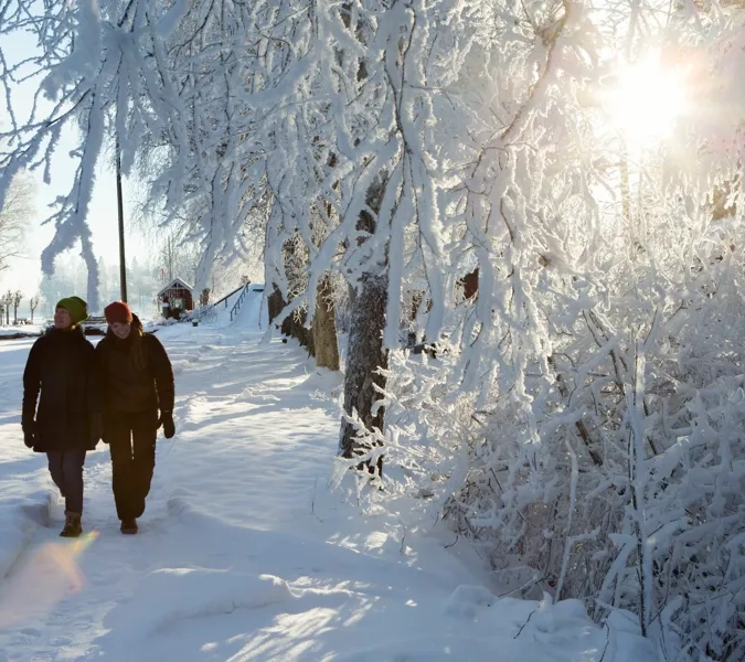 Et par mennesker som går i snøen.