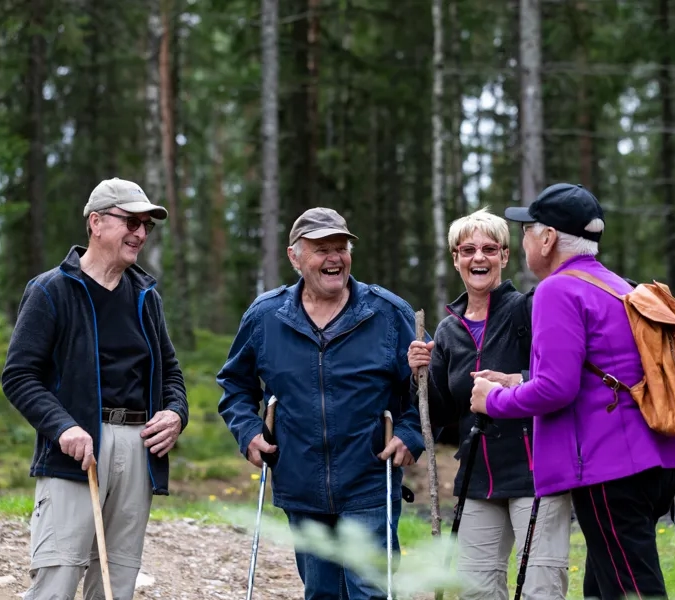 A group of people standing next to each other in the woods.