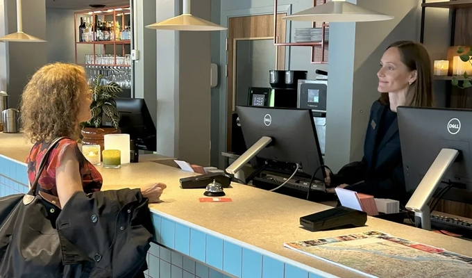 Glad receptionist med gäst 1