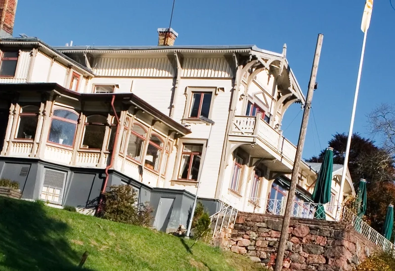 Ett stort hus som ligger på toppen av en grönskande sluttning.