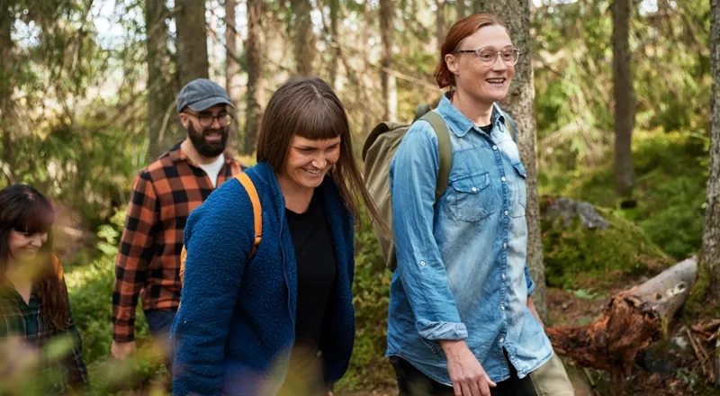 En grupp människor som går genom en skog.