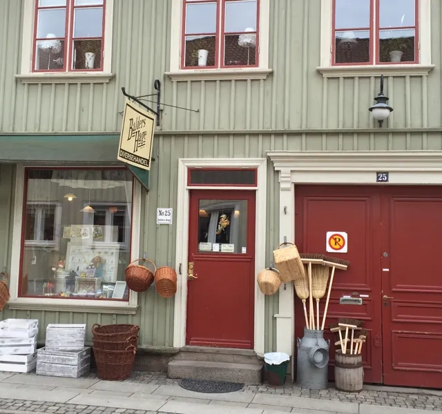 En grön byggnad med röda dörrar och fönster.