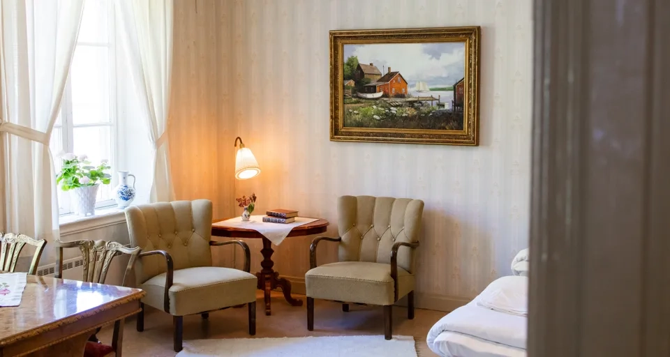 Ett vardagsrum fyllt med möbler och en tavla på väggen.