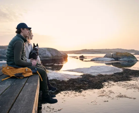 Ett par med hunden qlura i vintersol på ön Fotö