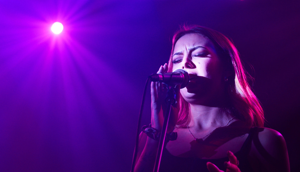 Kvinna sjunger på musikscen.
