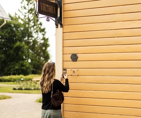 En kvinna som tar en bild av en skylt på sidan av en byggnad.