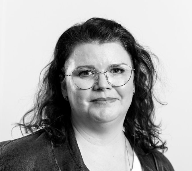 A black and white photo of a woman wearing glasses.