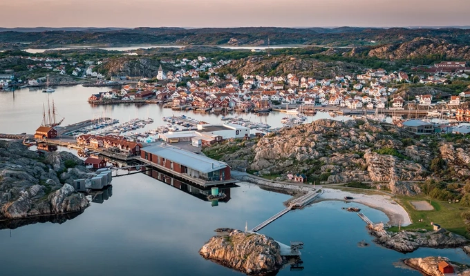 Flygbild över kustsamhälle i kvällssol.