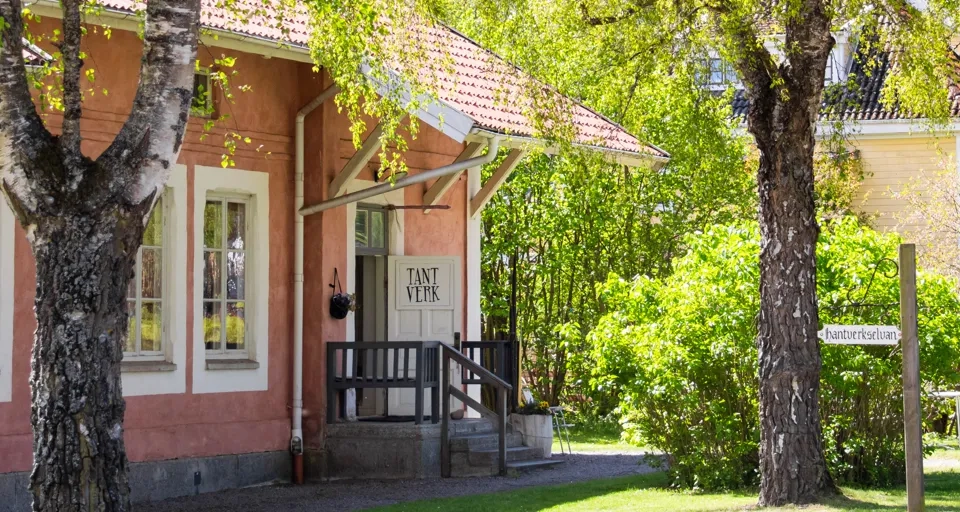 Falkängens hantverksby med historiska byggnader och grönskande omgivningar.