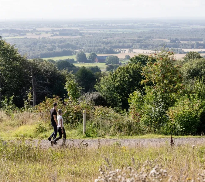 man och kvinna som vandrar på ett motionsspår. Vacker utsikt i bakgrunden.