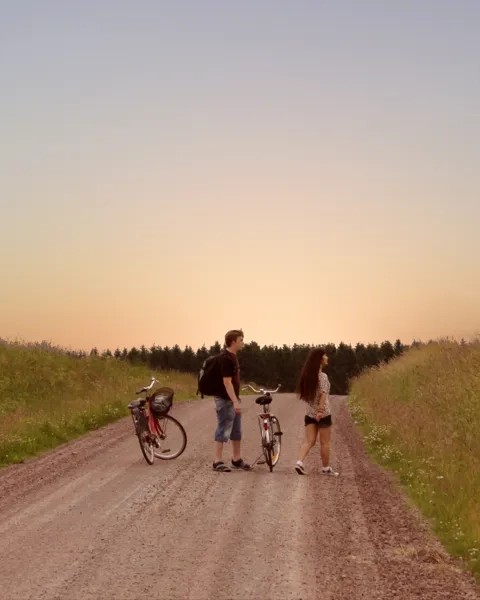 Man och kvinna som står på en grusväg med cyklar bredvid sig.