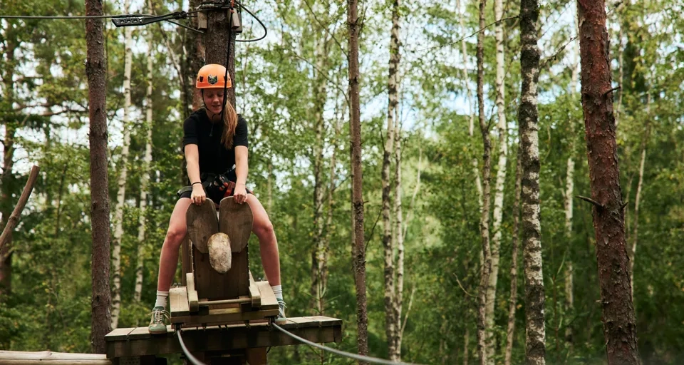 En person som åker linbana i skogen.