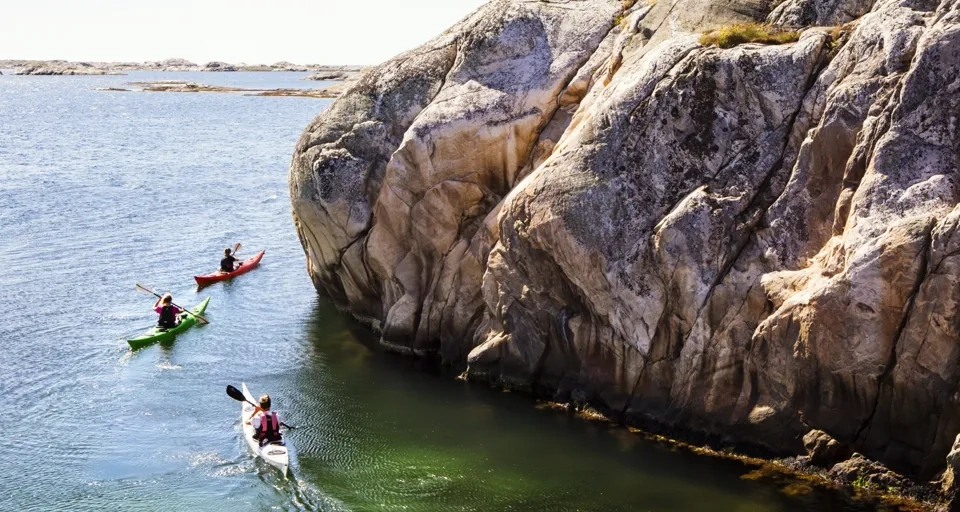 Två personer i kanoter paddlar på vattnet.