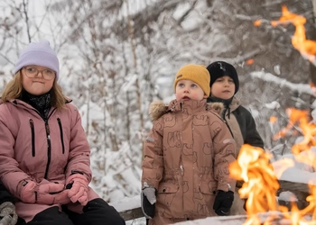En grupp människor som sitter runt en eldstad.