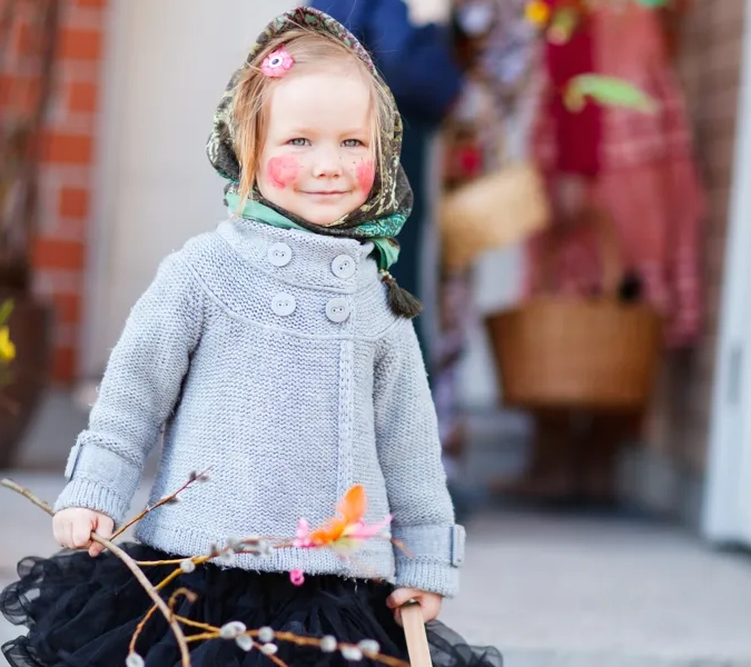 En lite flicka uppklädd som påskkärring