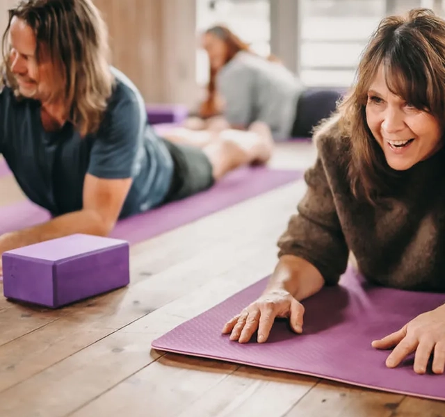 Personer som håller på med yoga i en yogastudio.