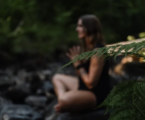 Kvinna yogar i skogen