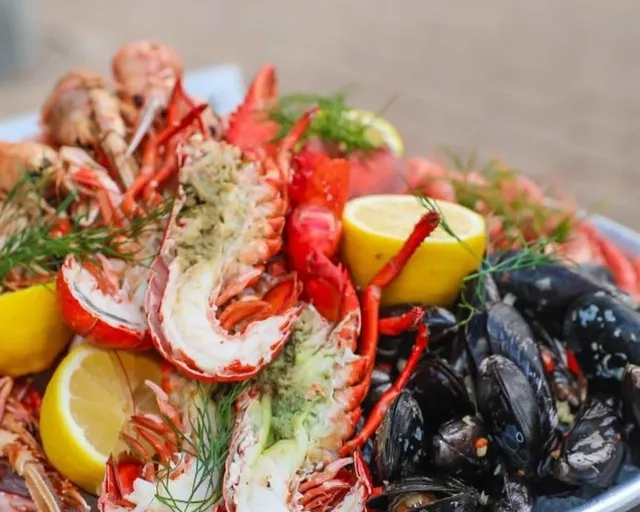 En tallrik med hummer, musslor och citronklyftor.