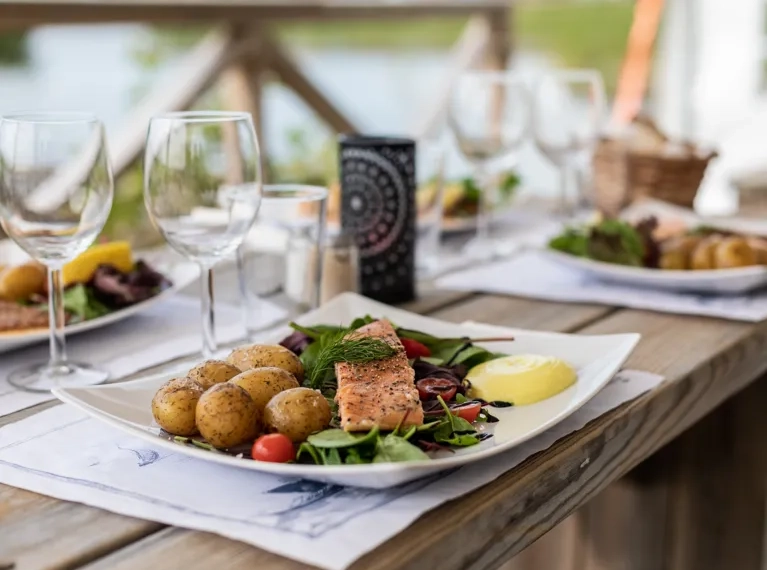 A wooden table topped with plates of food.