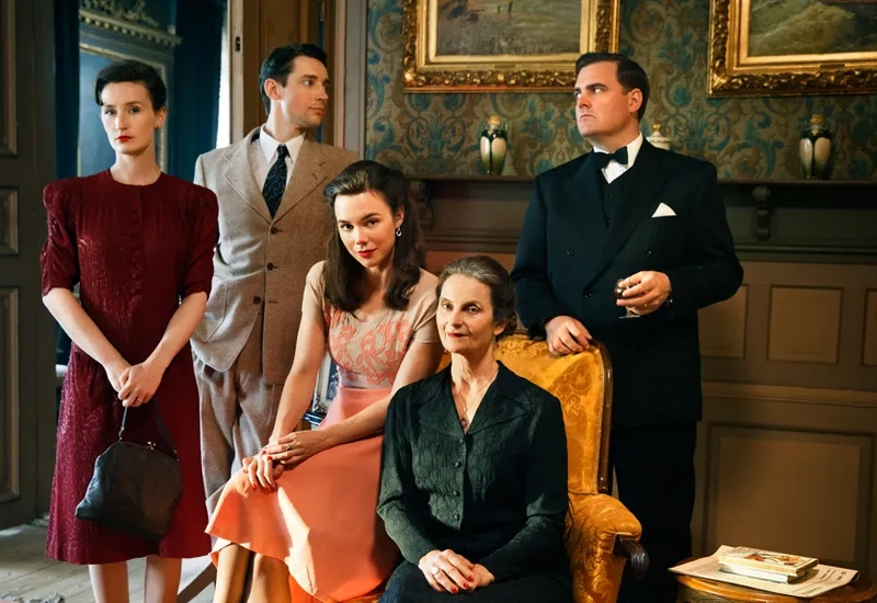 En grupp människor som står och sitter i ett rum.