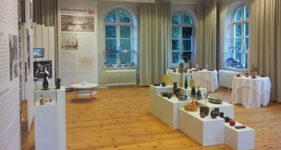 A room filled with lots of tables covered in white cloths.