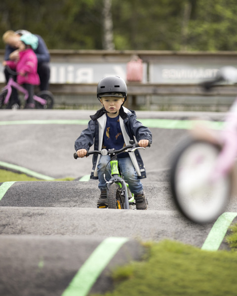 En liten pojke cyklar på pumptrack.
