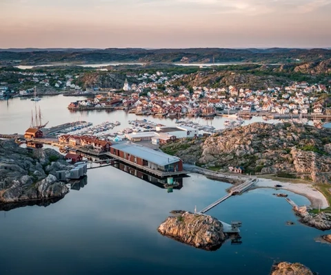 Flygbild över kustsamhälle i kvällssol.