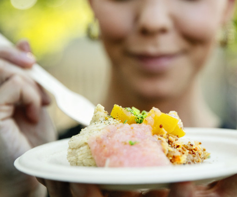 En närbild av en person som håller en tallrik med mat.