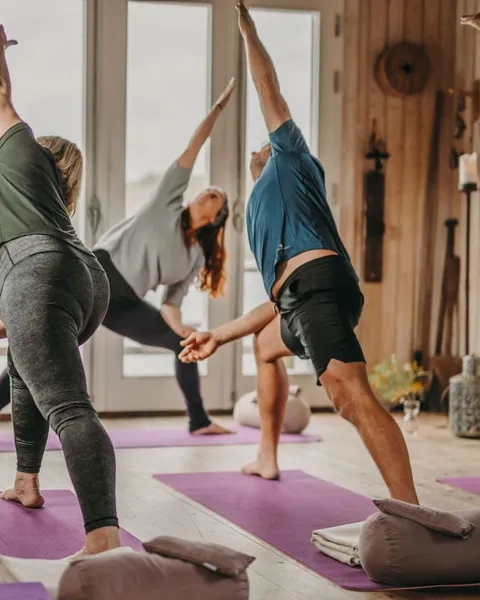 Personer som håller på med yoga i en yogastudio.