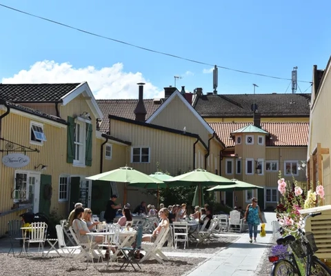 En grupp människor som sitter vid ett bord utanför en byggnad.