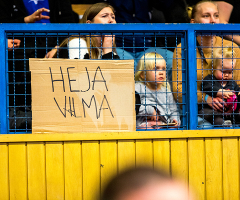 En grupp människor som håller en skylt bakom ett staket.