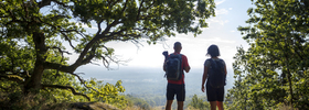 A couple of people standing on top of a hill.