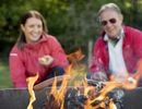 A man and a woman sitting in front of a fire pit.