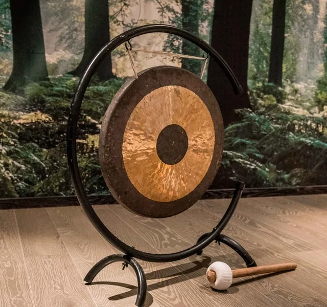 Mörk yogasal inredd för att utöva yoga, med en gong.