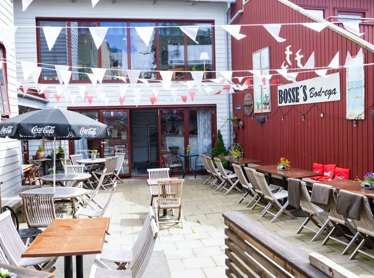 En uteplats med bord och stolar utanför en byggnad.