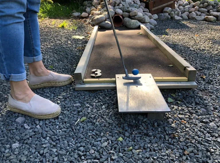A person standing in front of a miniature golf course.