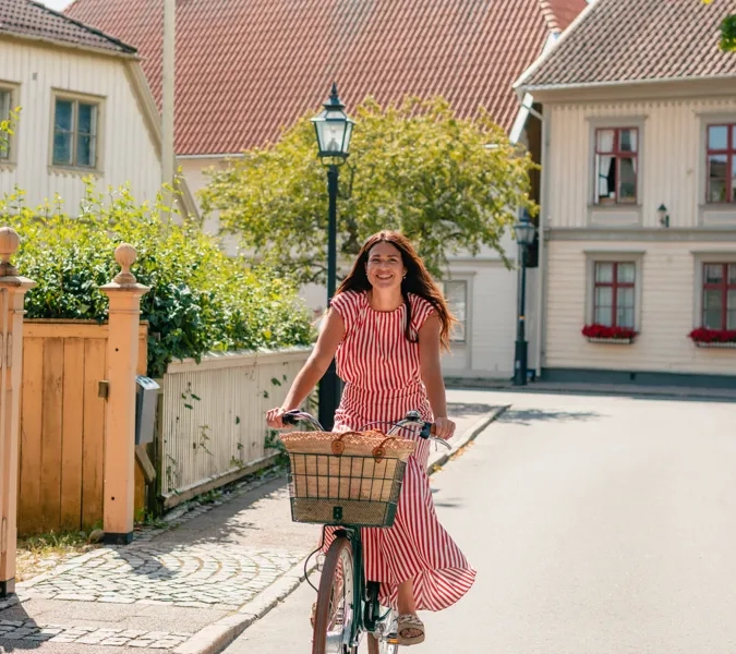 En kvinna cyklar längs en gata.