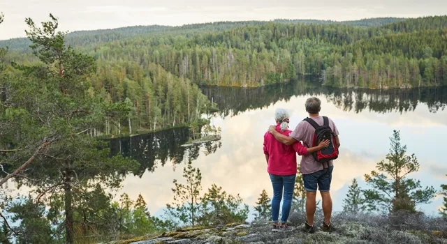 A couple of people standing on top of a hill.
