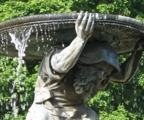 En staty av en man som håller i en skål med vatten.