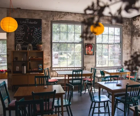 Brukslokal med träbord och stolar.