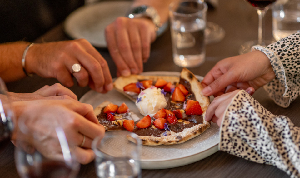 Matgäster delar maträtter i restaurangen på Tjörnbro Arena