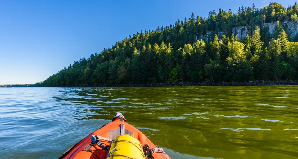 En kajak i mitten av en sjö med ett berg i bakgrunden.