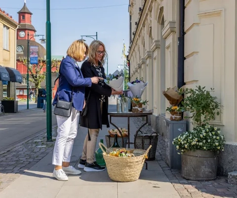 Två kvinnor promenerar i en småstad.