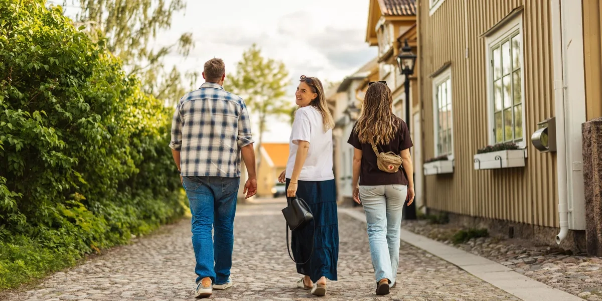 En grupp människor som går längs en kullerstensbelagd väg.