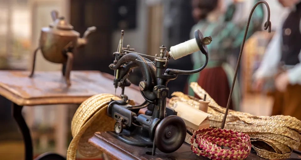 Utställning på Halmens hus. Halmhatt tillverkas på symaskin.