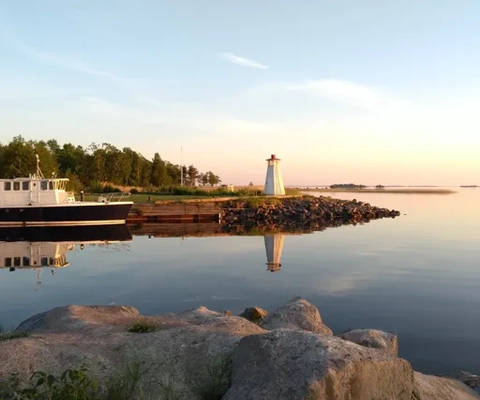 A boat is docked at the shore of a lake.