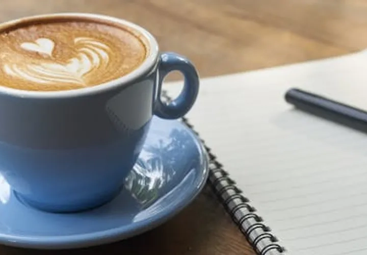 En kopp kaffe som står på ett blått fat.