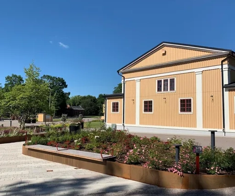 En byggnad med en trädgård framför sig.